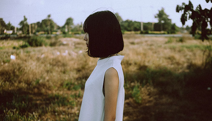 Femme asiatique aux cheveux courts regardant au loin dans une ferme