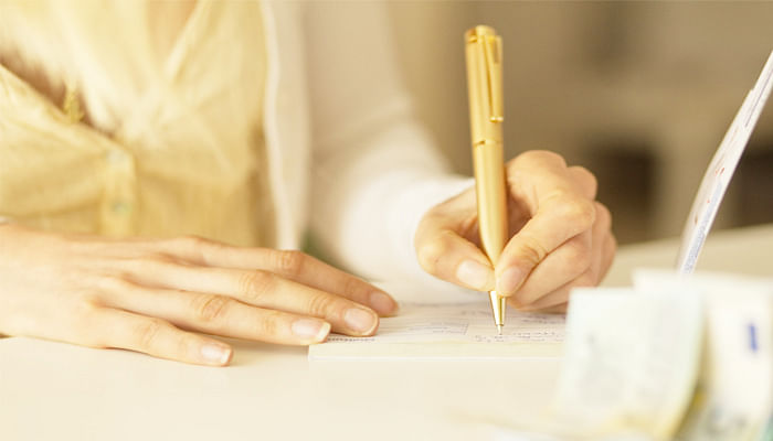 woman signing a cheque