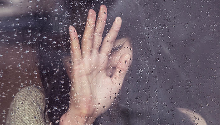 sad girl at the window on a rainy day